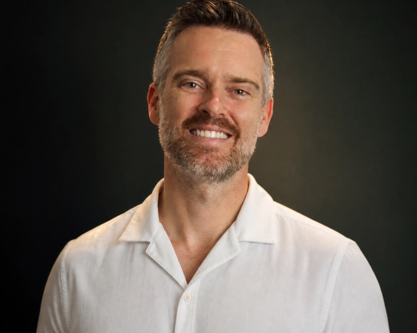 Dr. Matt Stapleton, MD, Medical Director of omnyx, smiling in a white shirt.