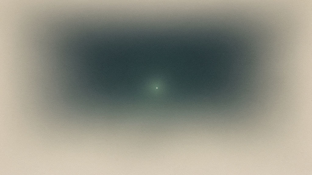 A bone field settling into teal darkness with one small, steady point of light at its center, a quiet signal held against the night.