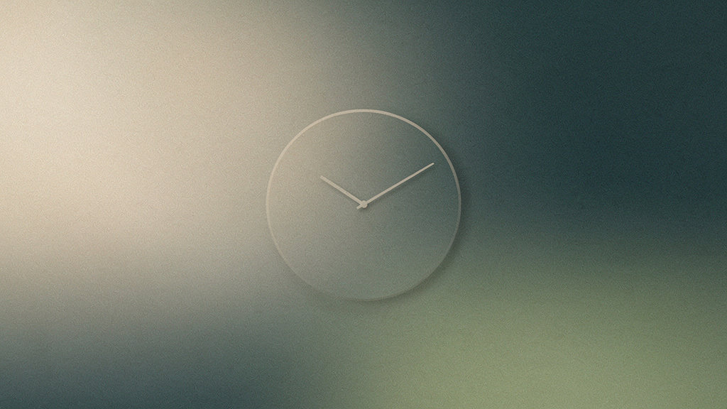 A faint bone-and-teal dial, its single hand eased a few degrees to one side, the face unchanged but for that small, deliberate shift in time.
