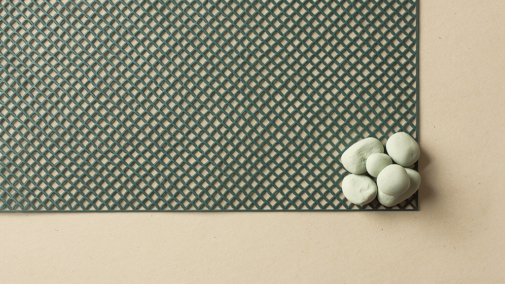 A cool desaturated teal engineered lattice fills most of a warm bone field while a small cluster of soft pale matcha forms rests in one corner, an abstract image of an ultra-processed default surrounding a small deliberate share of whole food.
